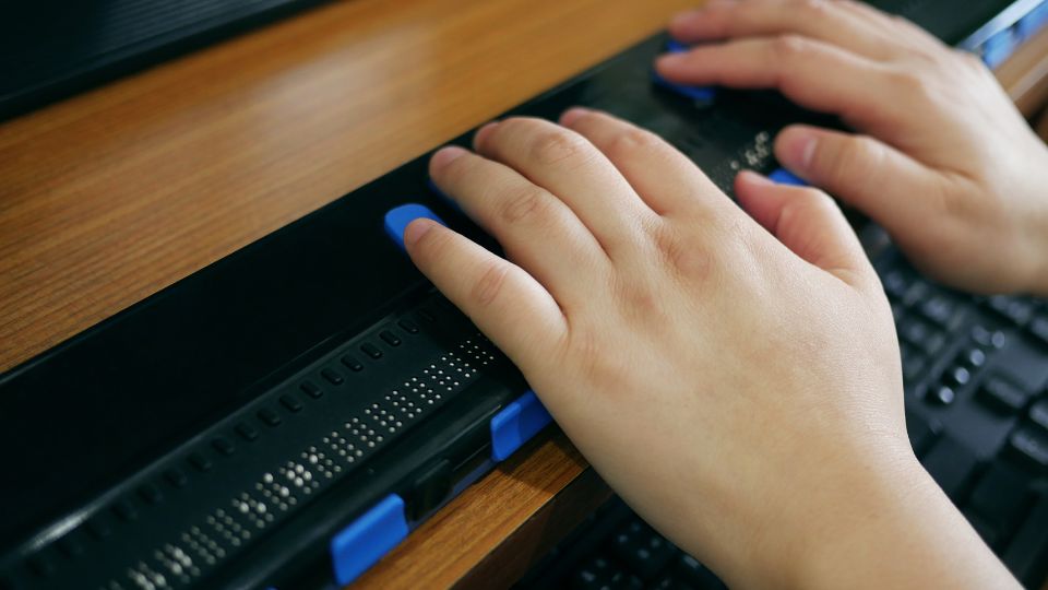 Closeup of hands on a braille display