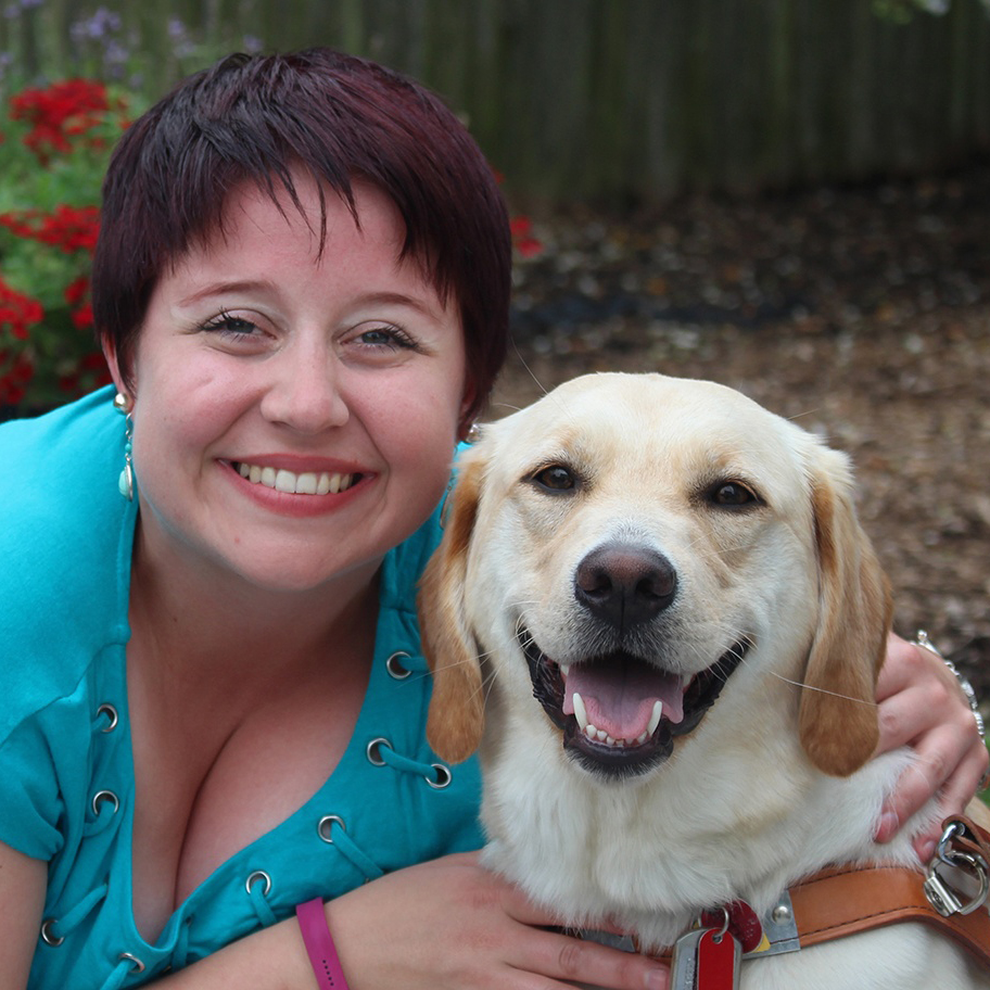 Photo of Colleen Connor, a young woman with purple hair in a pixie cut. She is hugging a Yellow Lab.