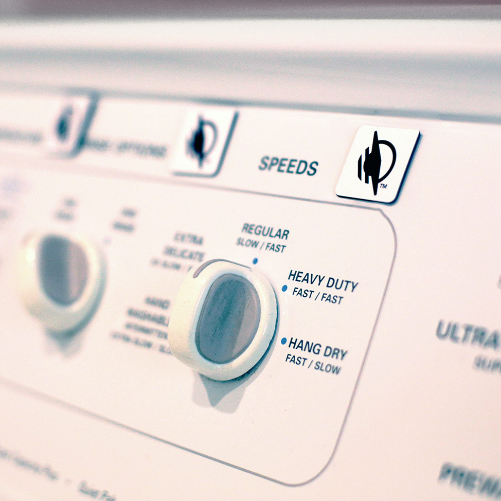WayTag stickers applied to a washing machine above its various knobs